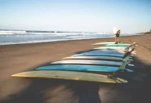 Longboards laying on bali beach with woman