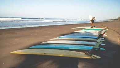 Longboards laying on bali beach with woman