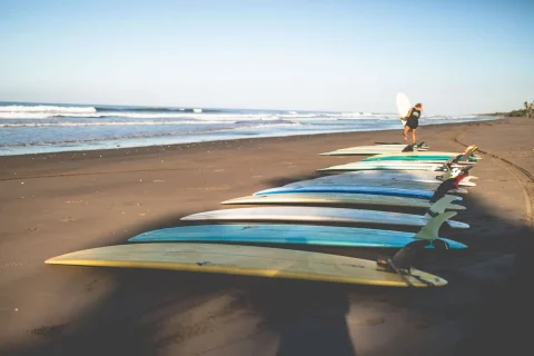 Longboards laying on bali beach with woman