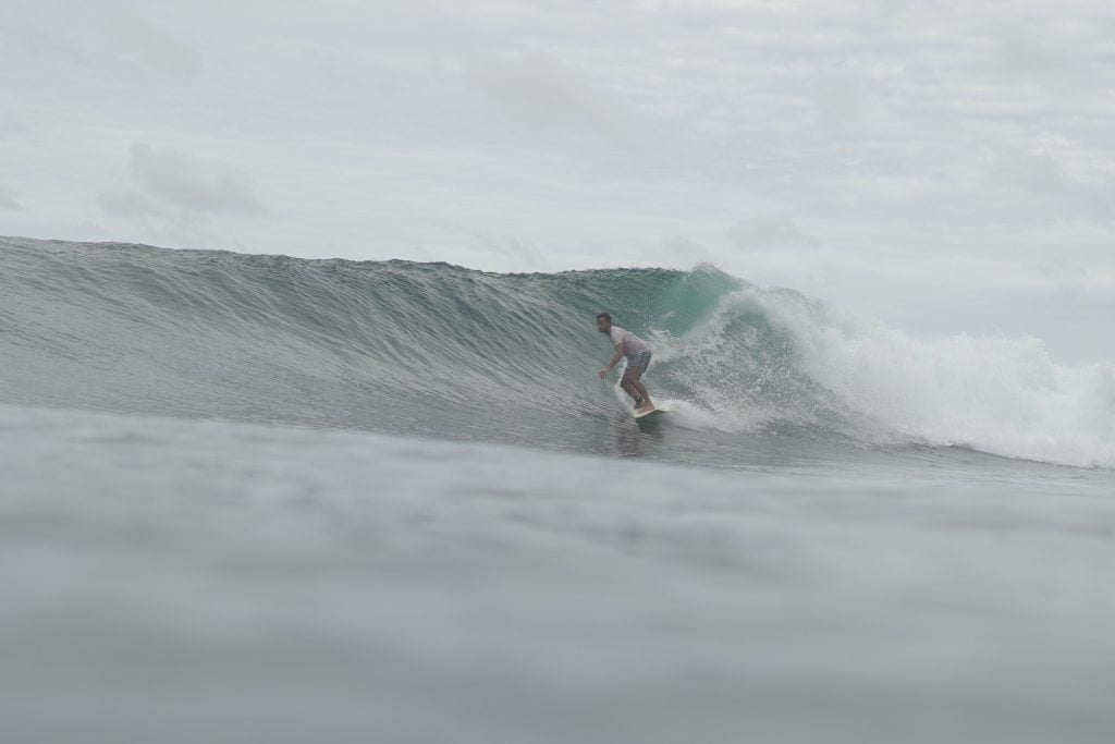 Intermediate surfer on wave in North Sumatra Indonesia