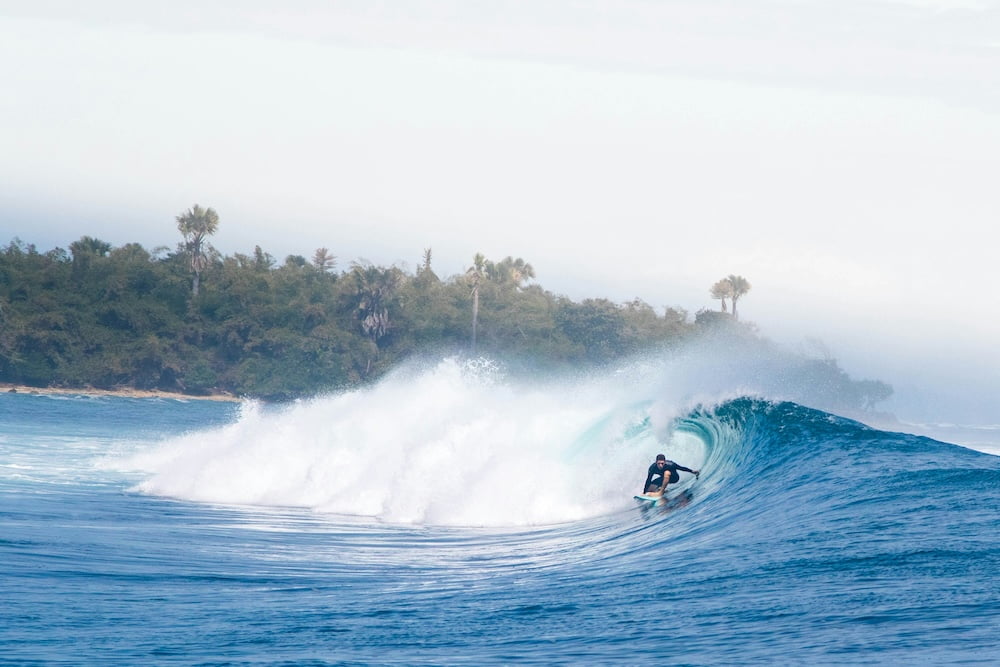 Surfer riding a wave at an Indonesian surf break.